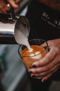 Barista pouring latte art into a coffee cup